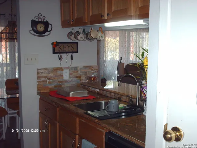 a kitchen with a sink and a stove next to a window