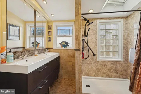 a bathroom with a sink mirror and a shower