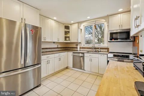 a kitchen with white cabinets and appliances
