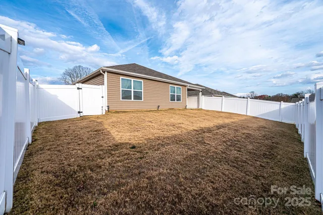 a kitchen with stainless steel appliances granite countertop a stove a sink a refrigerator with a dining table and chairs