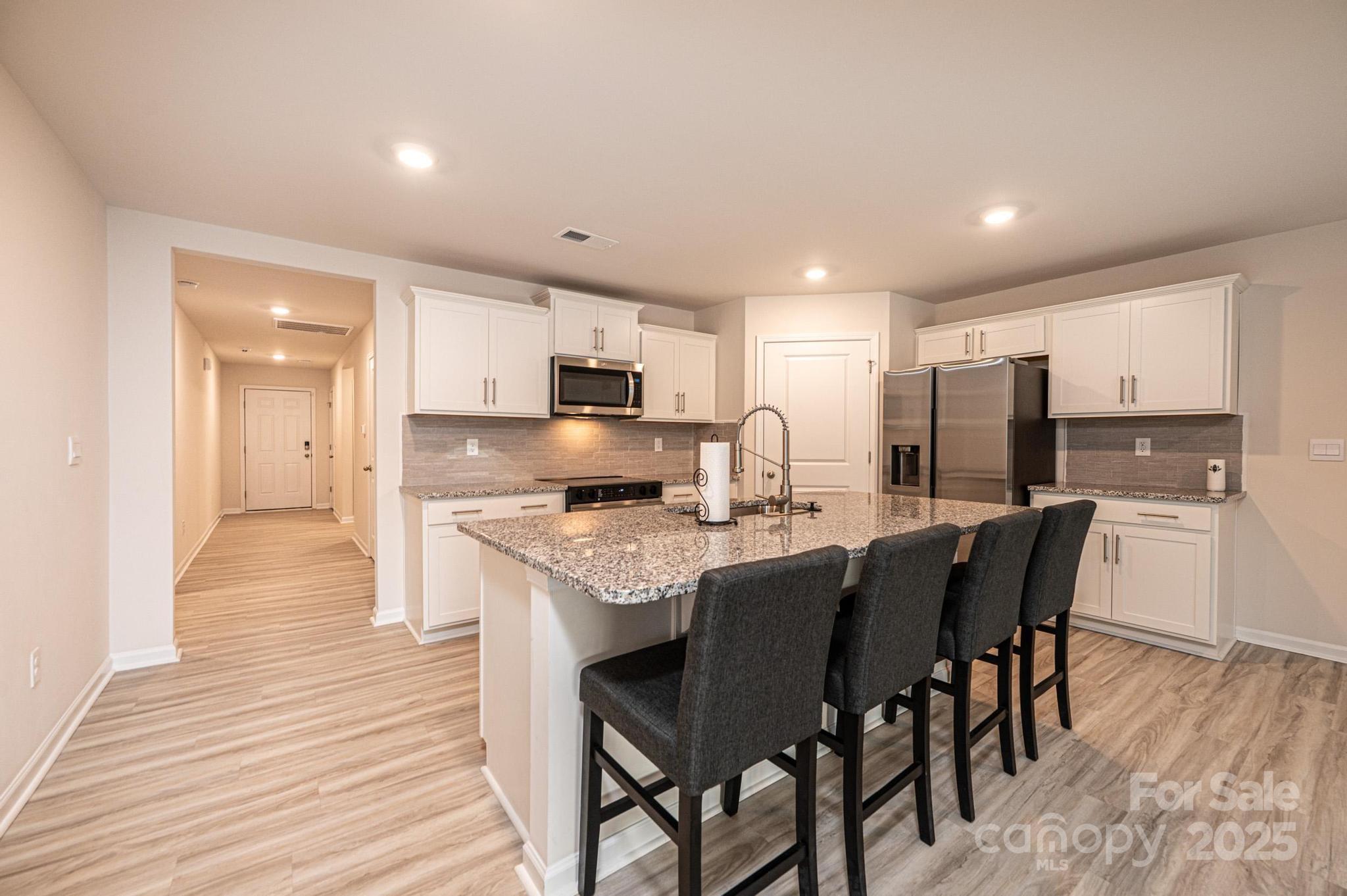 2542 Goose Fair Road Maiden, NC 28650 - Photo 13 of 48 a kitchen with stainless steel appliances granite countertop a stove a sink a refrigerator with a dining table and chairs