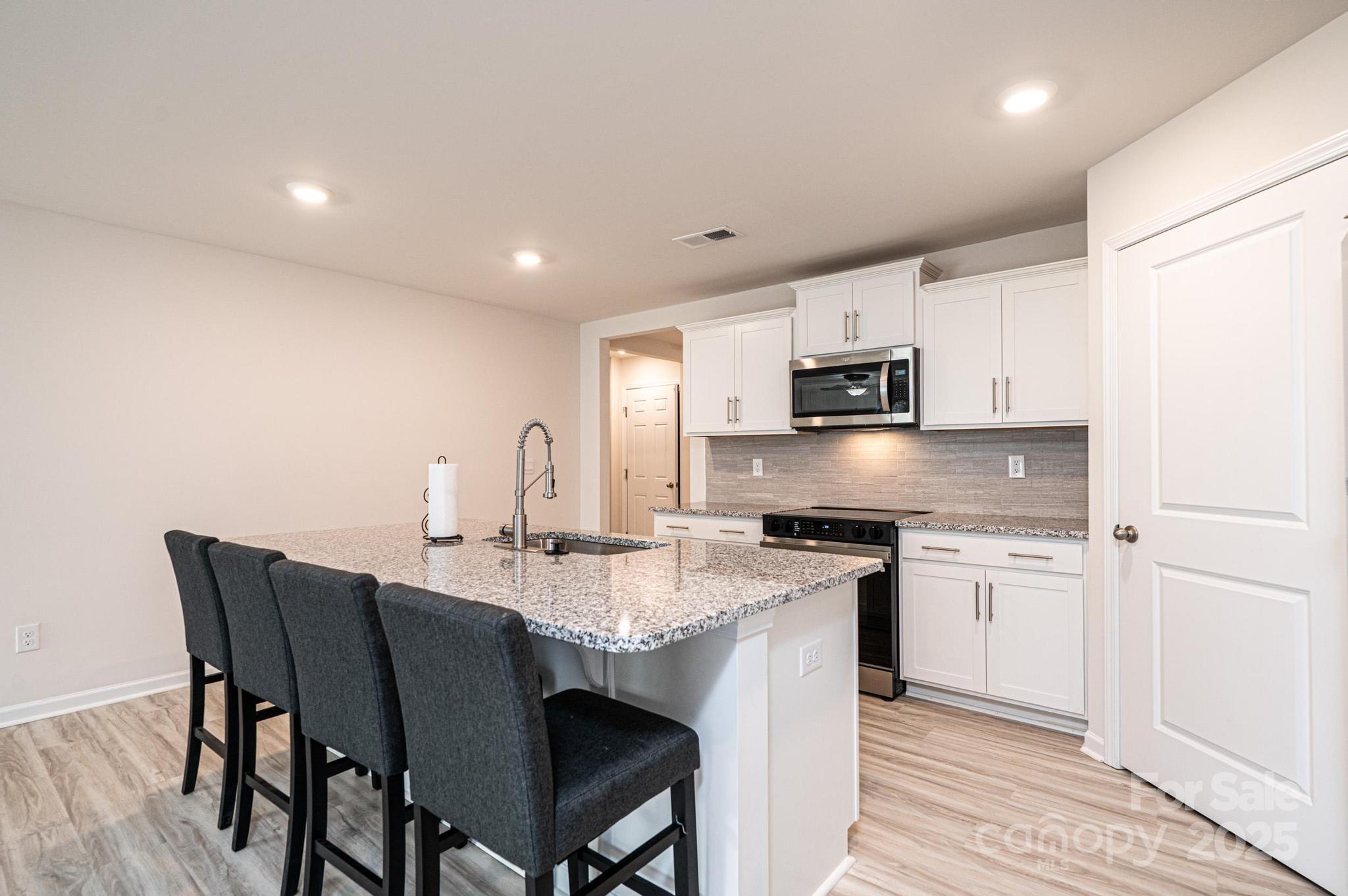 2542 Goose Fair Road Maiden, NC 28650 - Photo 15 of 48 a kitchen with stainless steel appliances granite countertop a stove a sink a microwave a dining table and chairs