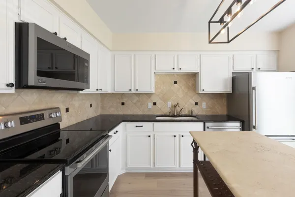 a kitchen with a sink stove and microwave