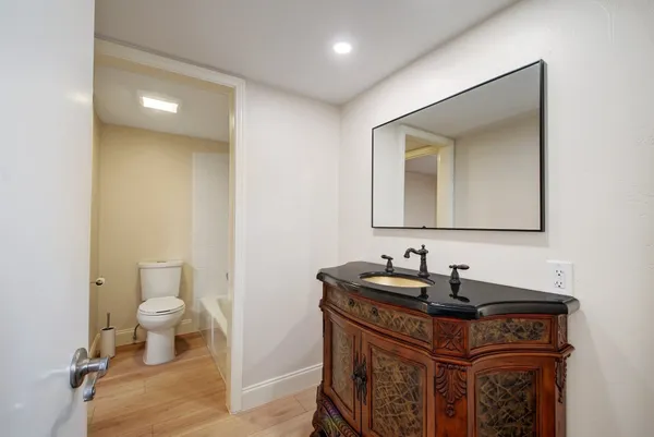 a bathroom with a bathtub sink vanity and mirror