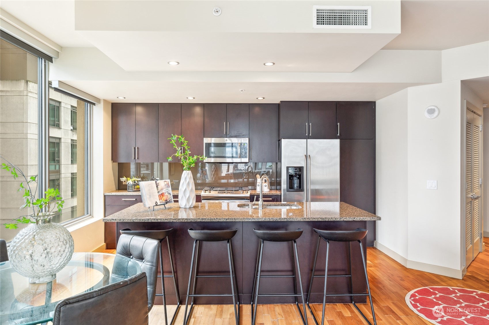 910 Lenora Street, Unit S907 Seattle, WA 98121 - Photo 17 of 38 a dining room with kitchen island granite countertop furniture a chandelier and kitchen view