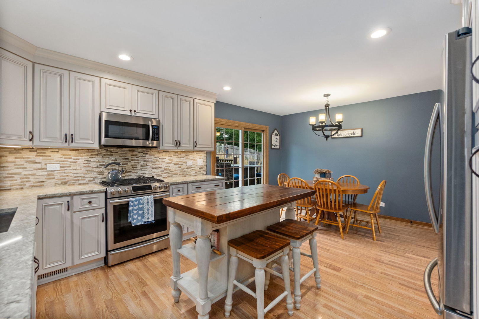 6N998 Riverside Drive St. Charles, IL 60174 - Photo 6 of 46 a kitchen with granite countertop a table chairs microwave and cabinets