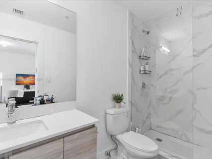 a bathroom with a sink vanity mirror and toilet