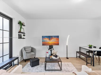 a living room with furniture a rug and a flat screen tv