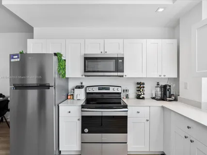 a kitchen with a refrigerator a stove a microwave and cabinets