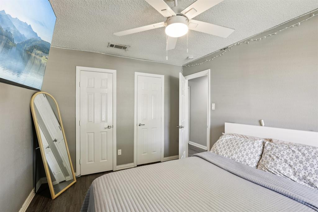 102 East Ridgegate Drive Garland, TX 75040 - Photo 18 of 31 a bedroom with a large bed and a chandelier