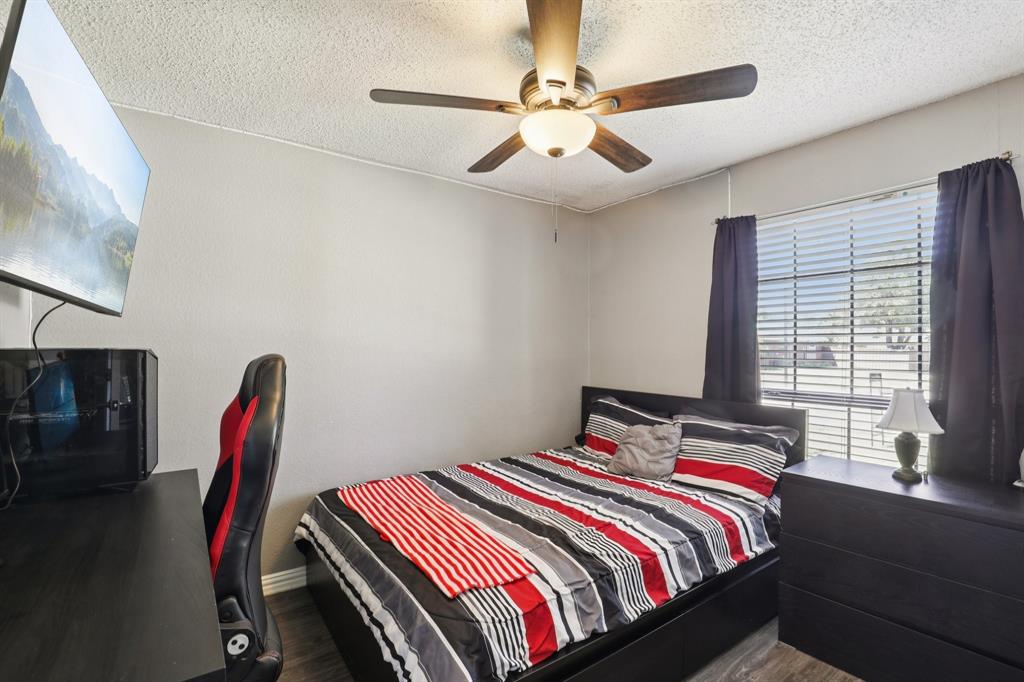 102 East Ridgegate Drive Garland, TX 75040 - Photo 19 of 31 a bedroom with a bed and a chandelier