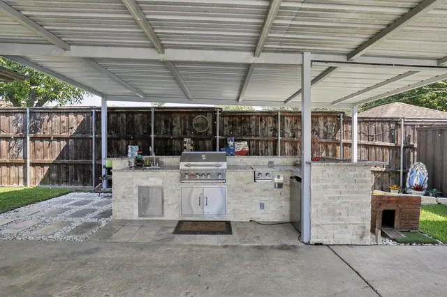 a view of patio with a table and chairs under an umbrella