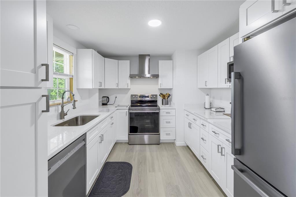 592 Ken Hubbard Road Terra Ceia, FL 34250 - Photo 12 of 34 a kitchen with granite countertop a sink stove and refrigerator