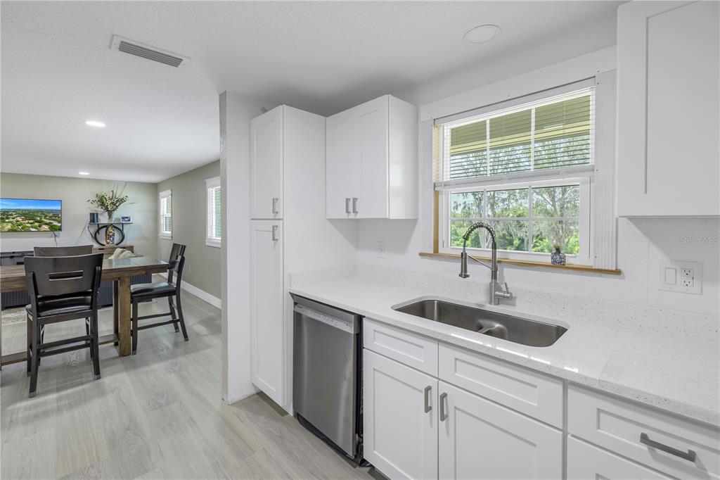 592 Ken Hubbard Road Terra Ceia, FL 34250 - Photo 14 of 34 a kitchen with stainless steel appliances granite countertop a sink a stove and a refrigerator with wooden floor