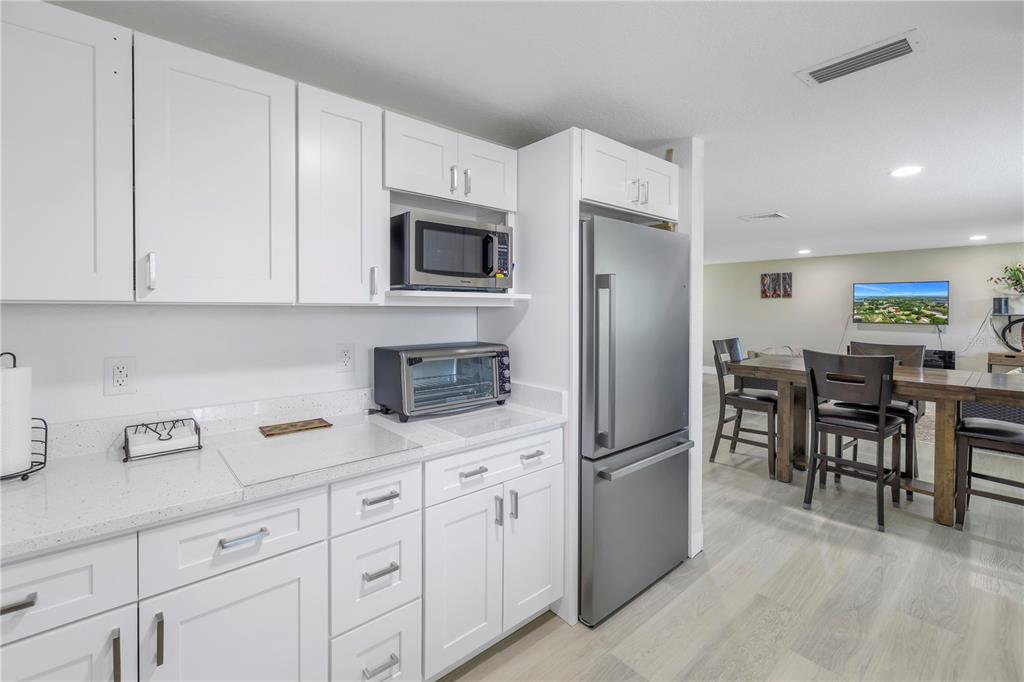592 Ken Hubbard Road Terra Ceia, FL 34250 - Photo 16 of 34 a kitchen with white cabinets and stainless steel appliances