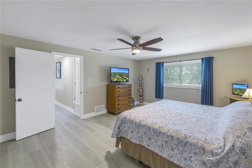 592 Ken Hubbard Road Terra Ceia, FL 34250 - Photo 18 of 34 a bedroom with a large bed and a chandelier