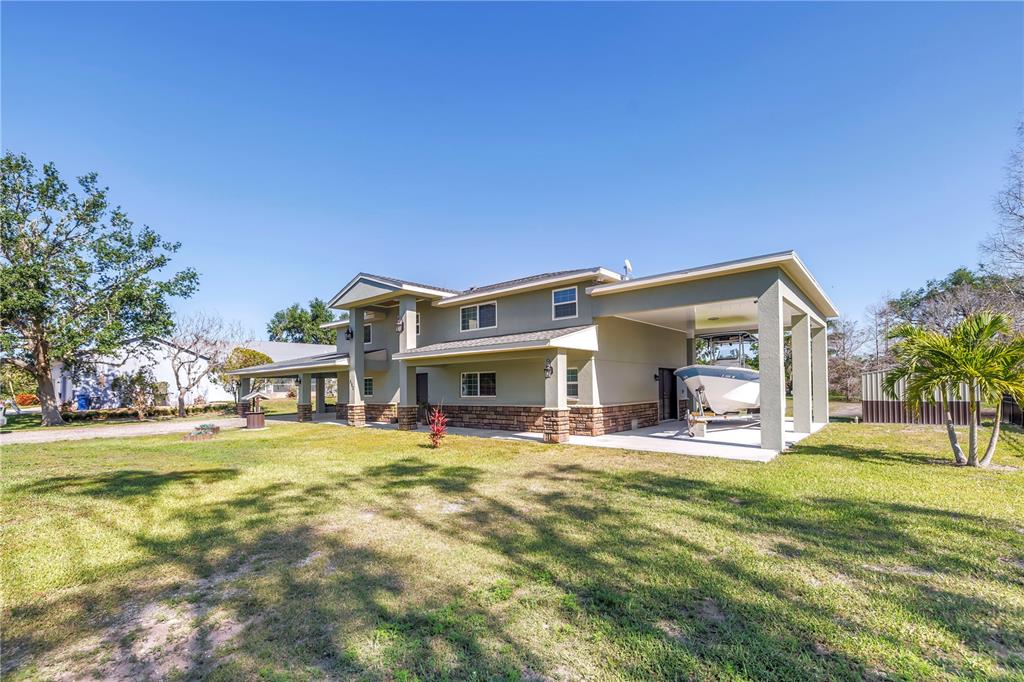592 Ken Hubbard Road Terra Ceia, FL 34250 - Photo 3 of 34 a view of a house with a yard patio and fire pit
