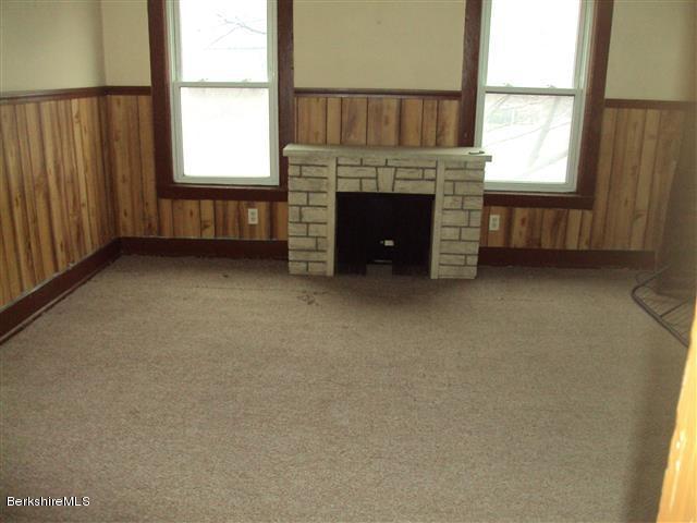 164 Columbia Street Adams, MA 01220 - Photo 6 of 9 an empty room with fireplace and windows