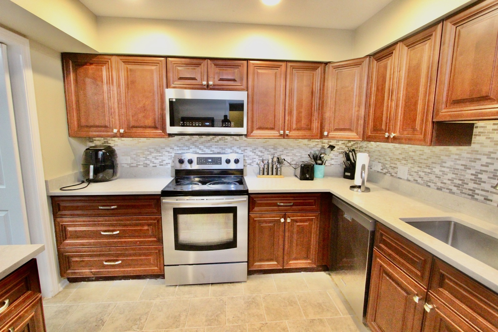 835 Suffield Square Lincolnshire, IL 60069 - Photo 12 of 44 a kitchen with stainless steel appliances granite countertop a sink stove and microwave