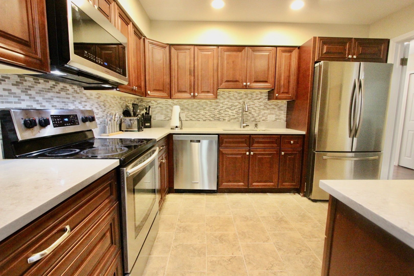 835 Suffield Square Lincolnshire, IL 60069 - Photo 10 of 44 a kitchen with stainless steel appliances a sink dishwasher stove and refrigerator with wooden floor