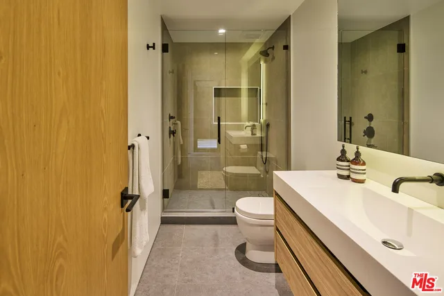 a bathroom with a sink a toilet and shower