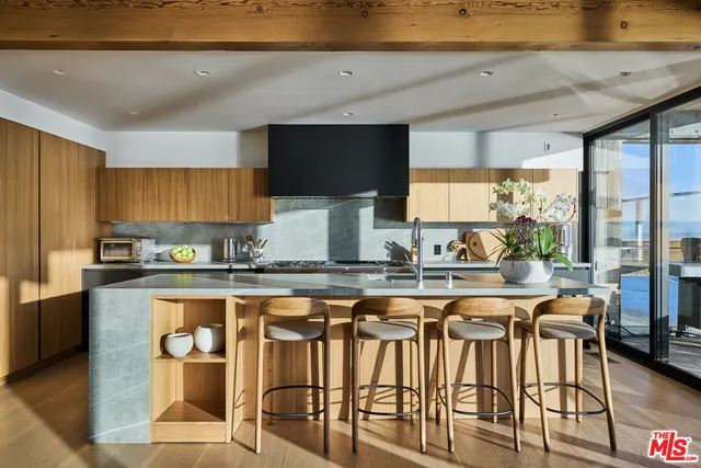 a kitchen with stainless steel appliances granite countertop table chairs sink and cabinets