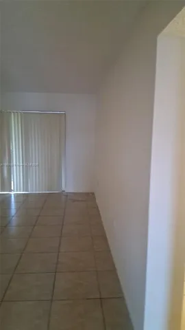 a view of a livingroom with an empty space and a window