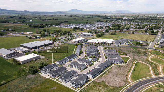 2483 South 1296th Street West Logan, UT 84321 - Photo 42 of 45 Aerial perspective showcasing a residential community surrounded by green fields and distant mountains