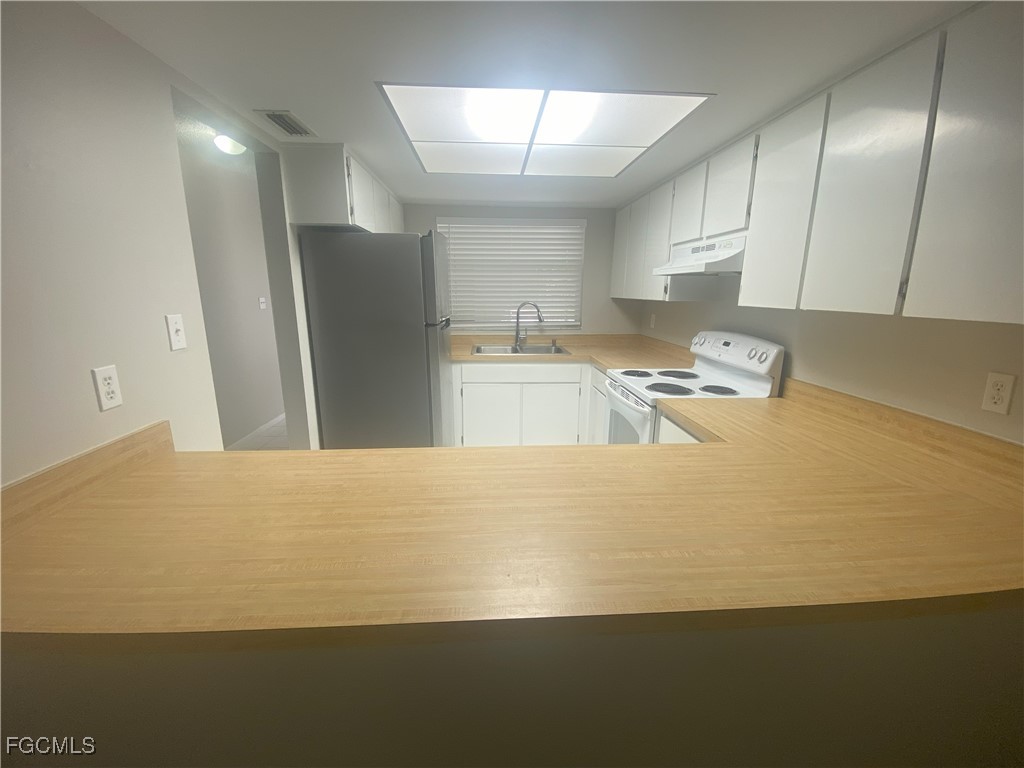 2258 Iris Way Fort Myers, FL 33905 - Photo 7 of 9 a kitchen with kitchen island a stove a refrigerator a sink dishwasher with a dining table and chairs