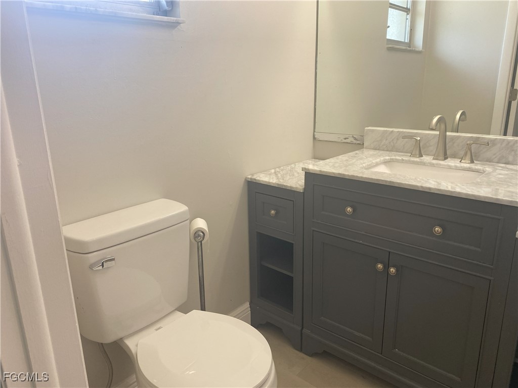 2258 Iris Way Fort Myers, FL 33905 - Photo 9 of 9 a bathroom with a toilet a sink and mirror