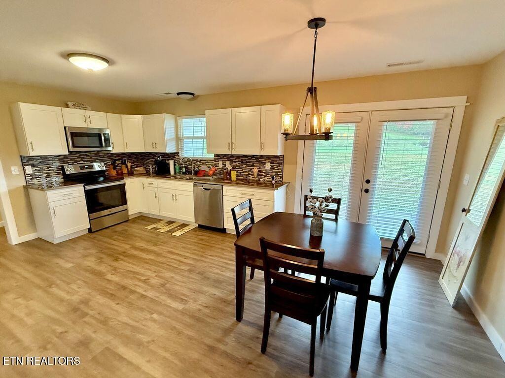 1825 Pleasant View Cemetery Road New Market, TN 37820 - Photo 8 of 19 a kitchen with microwave a stove a dining table and chairs