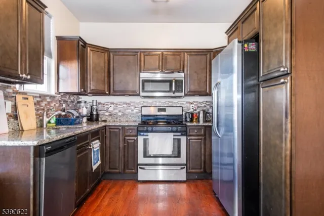 a kitchen with stainless steel appliances granite countertop a stove and a refrigerator