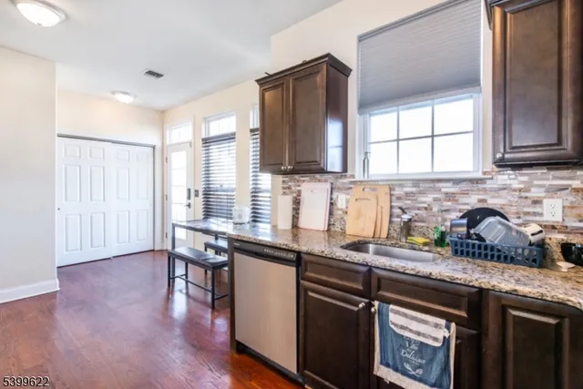 a kitchen with stainless steel appliances granite countertop wooden cabinets a sink and a window