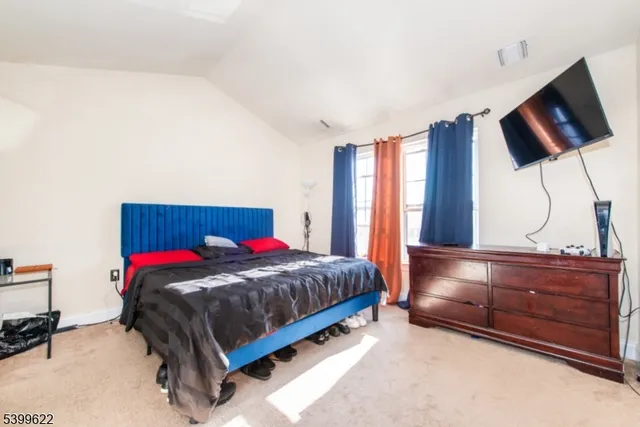 a living room with a bed furniture and a flat screen tv