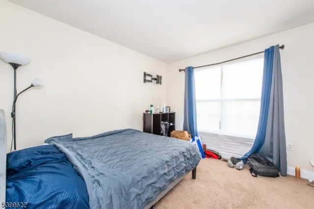 a bed sitting in a bedroom next to a window