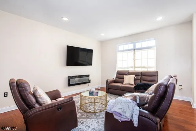 a living room with furniture a flat screen tv and a window