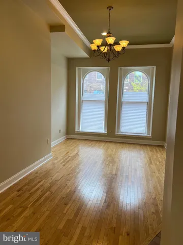 a view of a room with chandelier and wooden floor