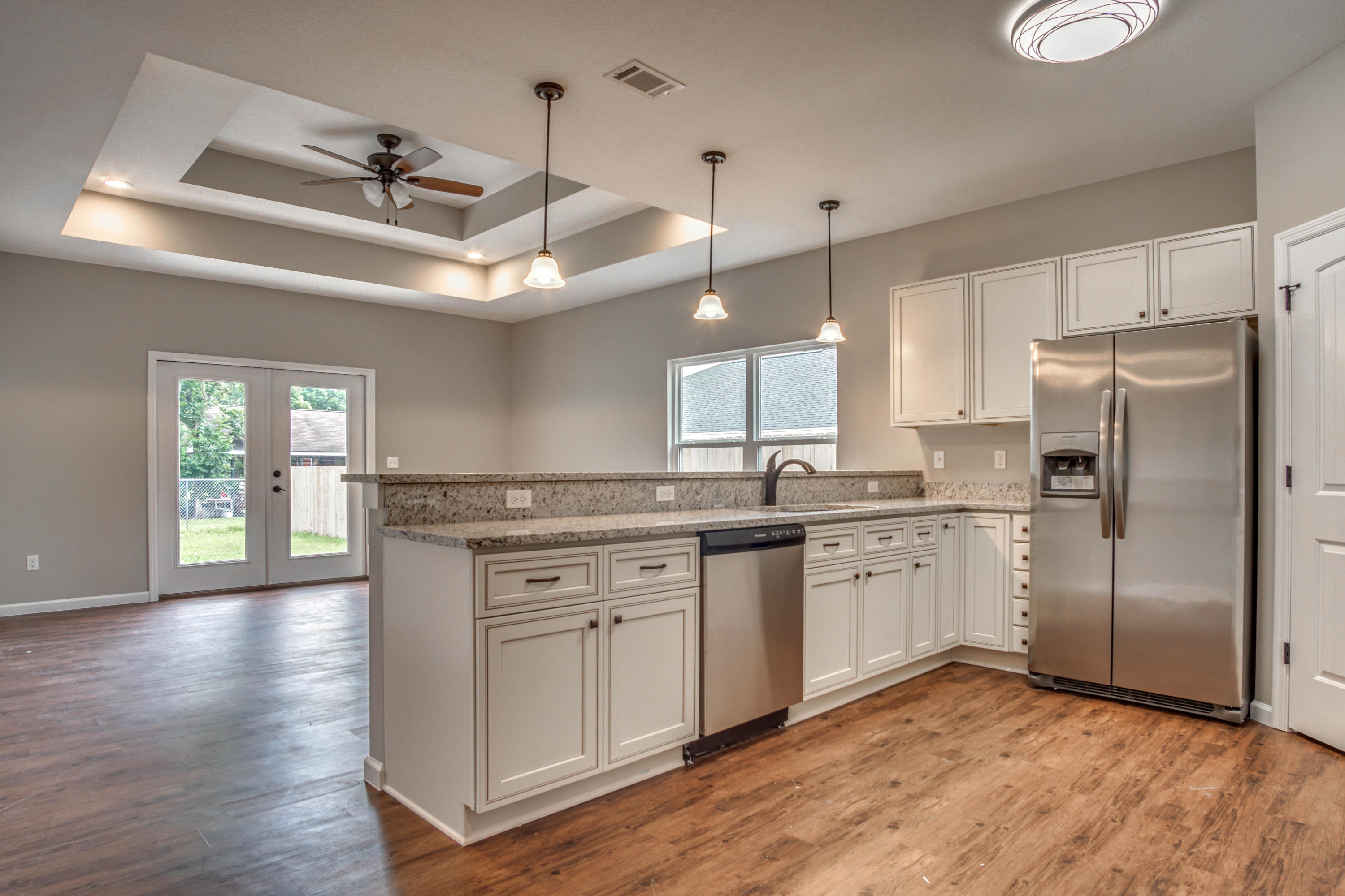 240 Dixie Street Crestview, FL 32536 - Photo 6 of 20 a kitchen with stainless steel appliances granite countertop a refrigerator a sink dishwasher a stove and white countertops with wooden floor