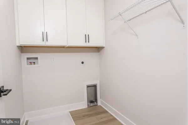 a view of a kitchen with white cabinets and a wooden floor
