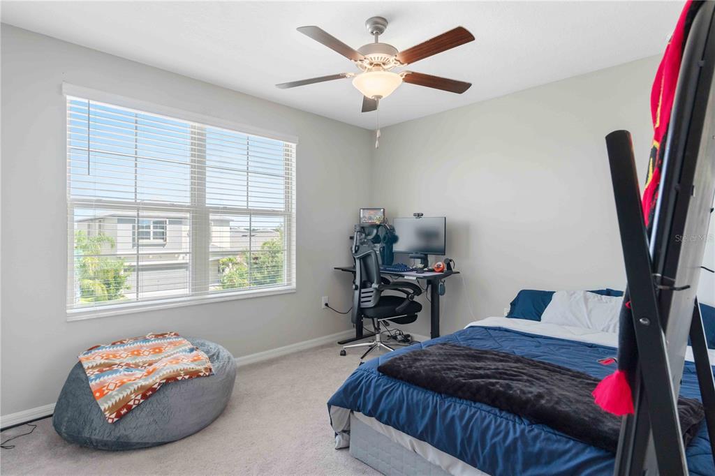 9440 Lemon Drop Loop Sun City Center, FL 33573 - Photo 41 of 55 a bedroom with a bed and a large window