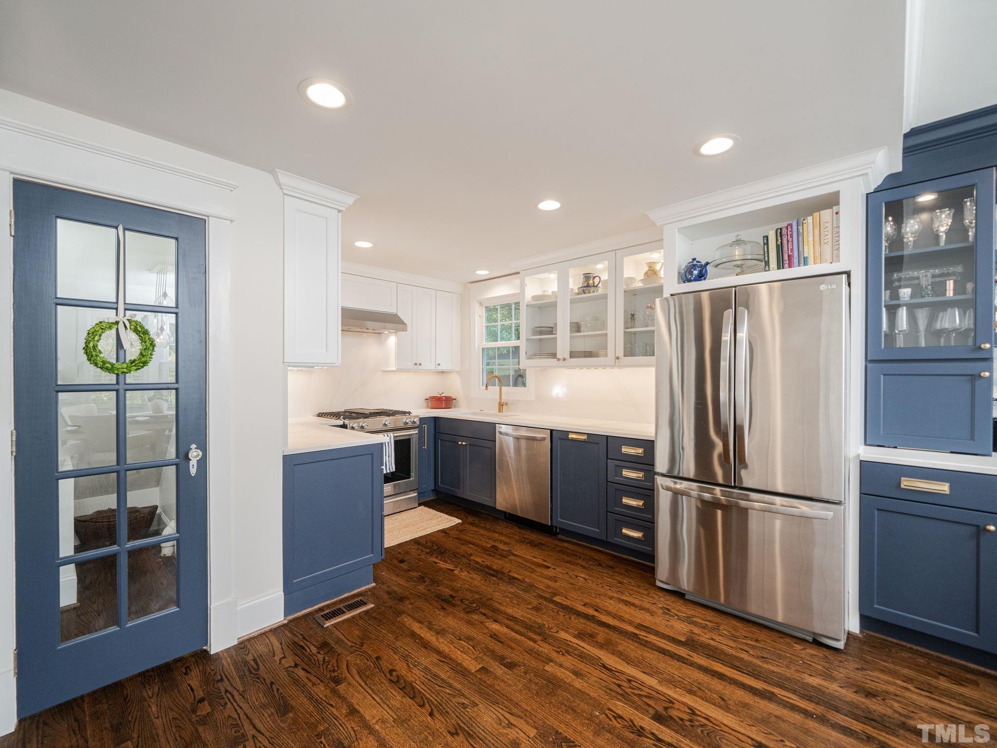 630 New Road Raleigh, NC 27608 - Photo 27 of 55 a kitchen with stainless steel appliances granite countertop a refrigerator cabinets and wooden floor