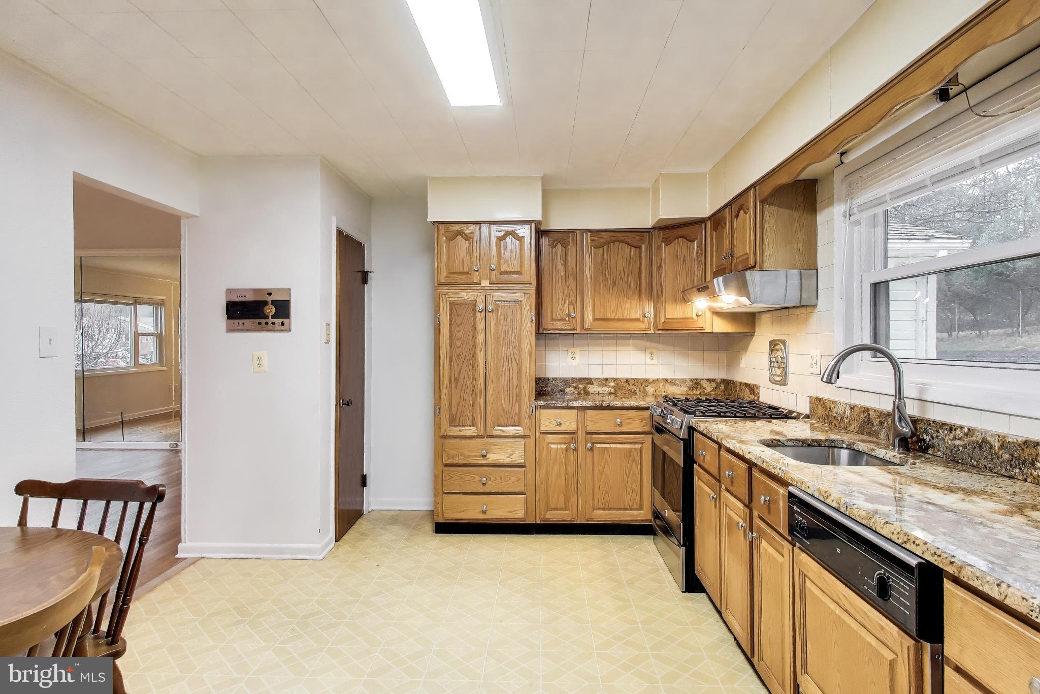 9233 Alcona Street Lanham, MD 20706 - Photo 12 of 43 a kitchen with stainless steel appliances granite countertop a stove a sink and a refrigerator