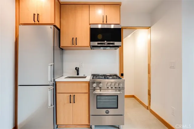 a kitchen with stainless steel appliances a refrigerator stove and microwave