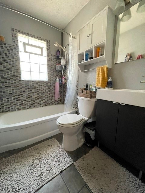 28634 Forest Road Willowick, OH 44095 - Photo 27 of 39 Updated bathroom featuring a bathtub with a tiled shower surround, a glass block window, dark floor tiling, a dark vanity with a white countertop, and a white wall-mounted storage cabinet