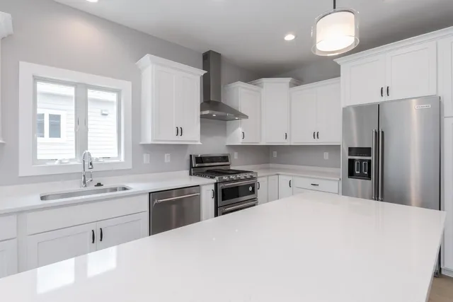 a kitchen with white cabinets and refrigerator
