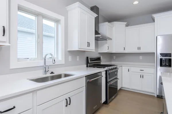 a kitchen with lot of cabinets and wooden floor