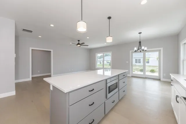 a large kitchen with stainless steel appliances granite countertop a sink a stove and a wooden floors