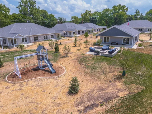 a view of a house with backyard and sitting area