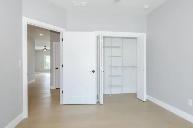 an empty room with closet and a bathroom