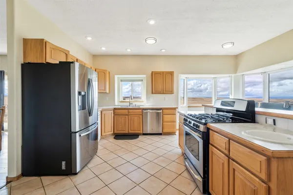 a kitchen with stainless steel appliances granite countertop a refrigerator a stove a sink and a refrigerator